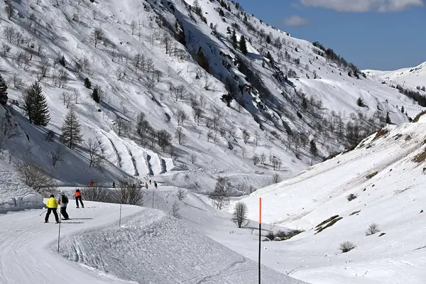 La piste de Sarenne dans les gorges de Sarenne, skieurs au loin