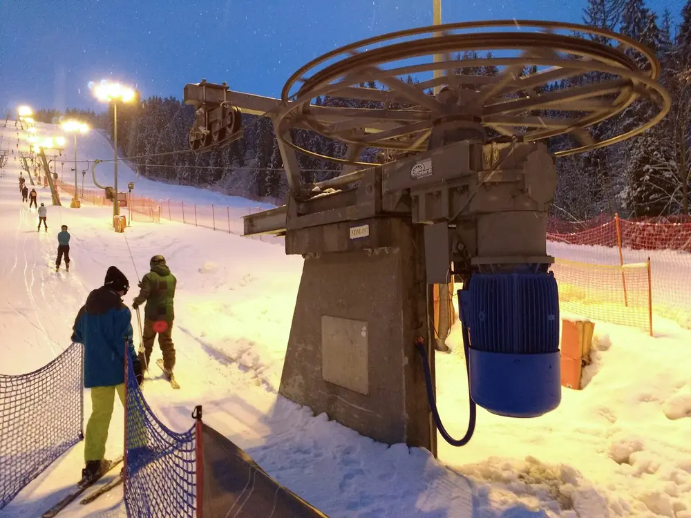 Nachts beleuchteter Schlepplift entlang einer Piste von Kotelnica Białczańska, Skifahrer von hinten, 18. Febr. 2017