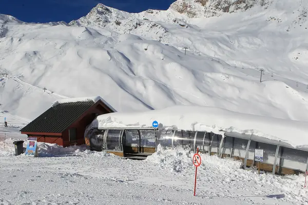 Tapis roulant couvert et chalet sous la neige au Cirque du Lys, pentes enneigées au fond (janvier 2013)