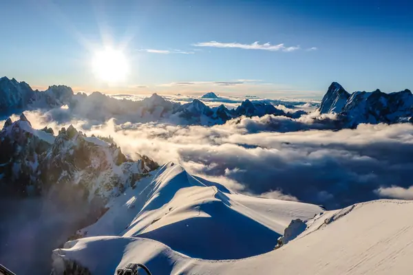Coucher de soleil sur les crêtes enneigées de Chamonix-Mont-Blanc, au-dessus d'une mer de nuages