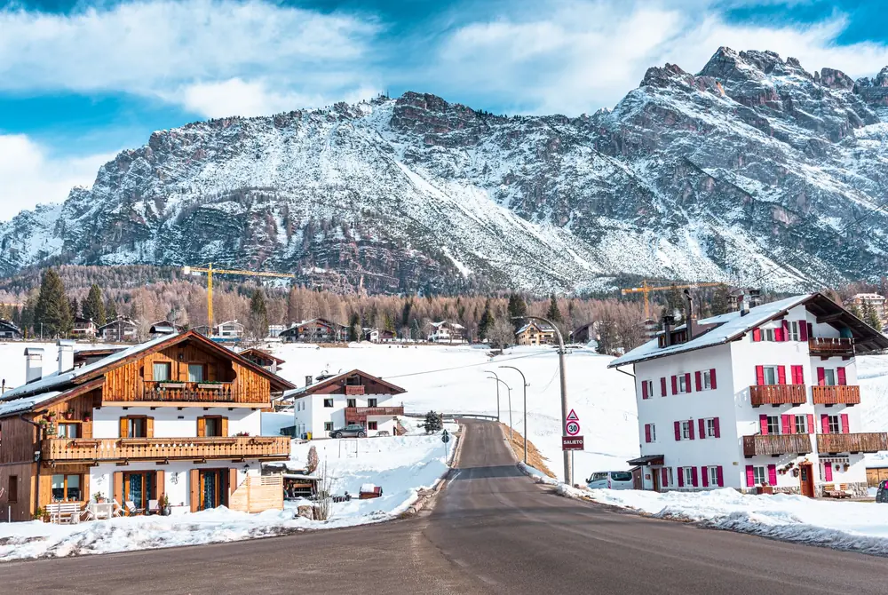 Maisons traditionnelles de Cortina d'Ampezzo dans la neige, devant les Dolomites