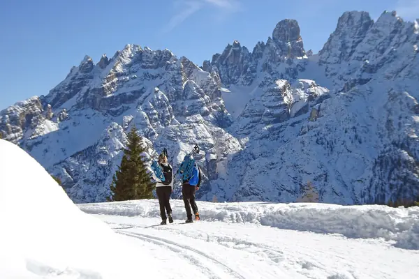 Deux randonneurs en raquettes face aux Dolomites enneigées, près de Cortina