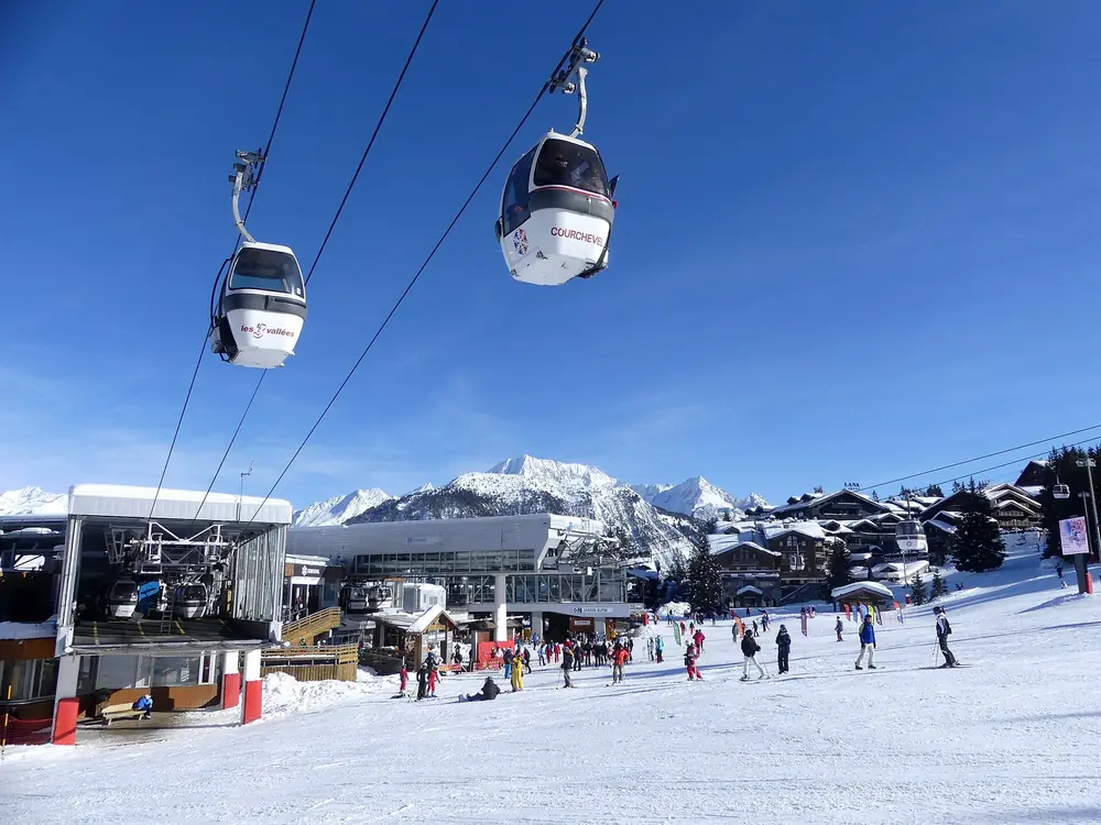 Front de neige de Courchevel 1850 et télécabine des Chenus, skieurs au pied des pistes