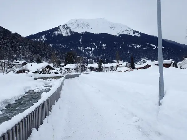 Klosters Platz sous la neige, chemin le long de la rivière et sommets