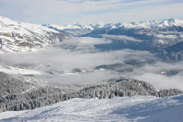 Piste au-dessus de Laax, mer de nuages sur la vallée, janvier