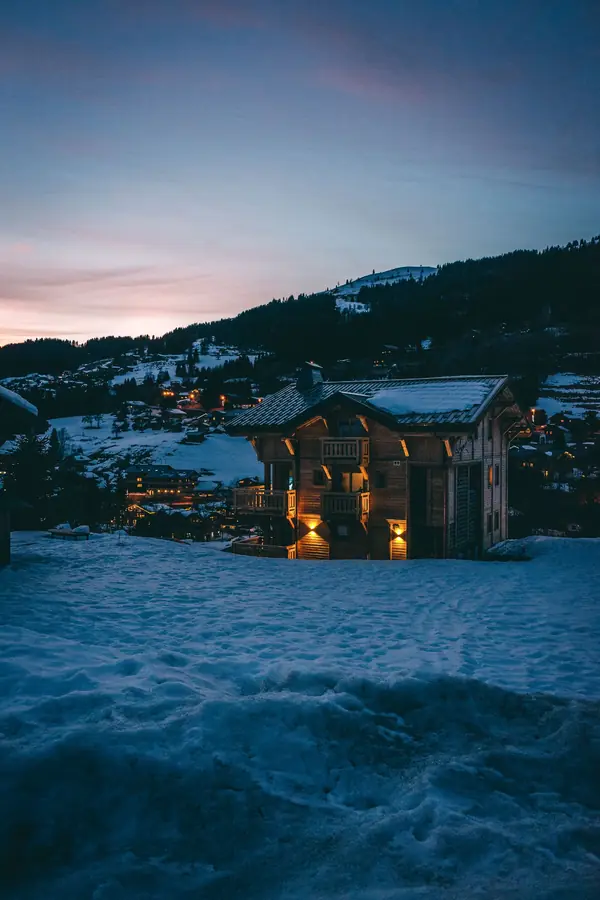Chalet éclairé dans la neige au crépuscule, aux Gets