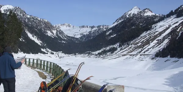 Lac de l'Oule enneigé, près du secteur Saint-Lary 2400, avec un randonneur et ses skis (mars 2010)