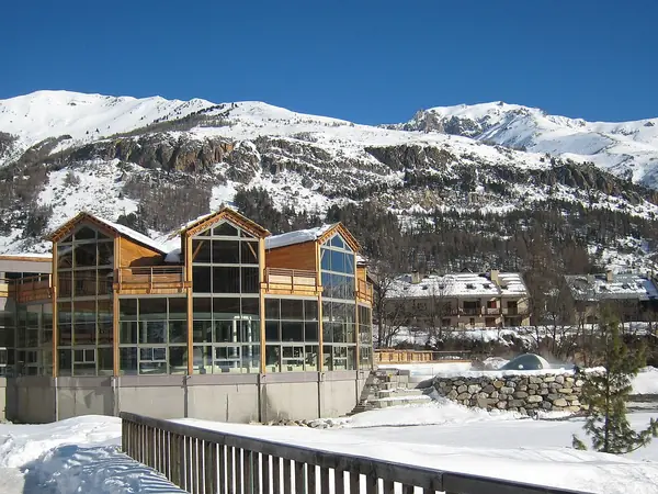 Les Grands Bains du Monêtier (Serre Chevalier 1500) sous la neige, avec le domaine en arrière-plan