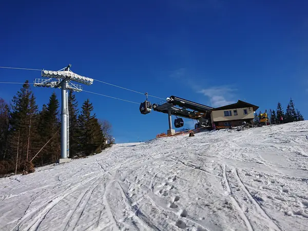 Bovenstation van gondel A1 bij Hala Skrzyczeńska en geprepareerde pistes, maart 2018