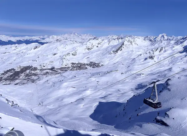 Une cabine du téléphérique de Caron au-dessus de Val Thorens et des sommets enneigés