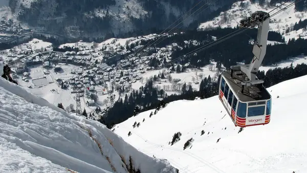 Cabine du téléphérique Wengen-Männlichen au-dessus du village enneigé (date non indiquée, hiver)