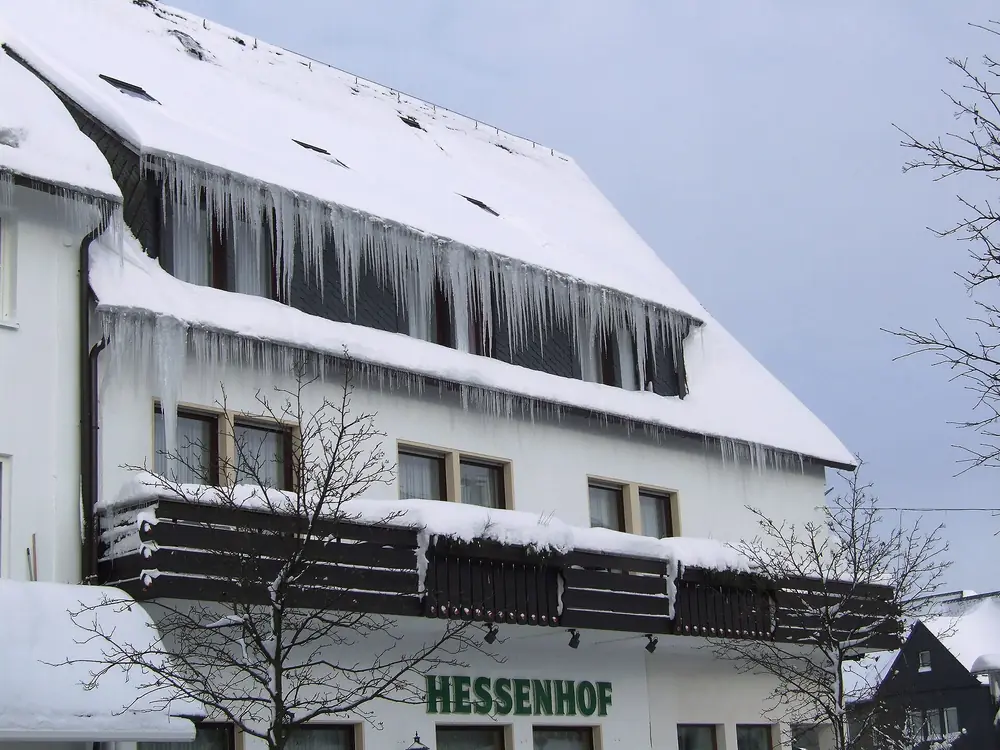 Façade d'un hôtel du centre de Winterberg, chargée de neige et de stalactites