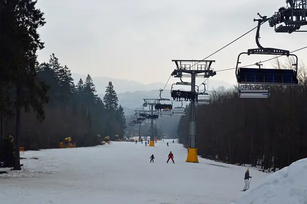 Skieurs sur la piste du Skiliftkarussell de Winterberg, sous les télésièges
