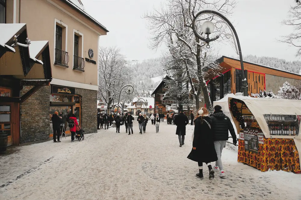 Rue piétonne enneigée du centre de Zakopane, animée de promeneurs