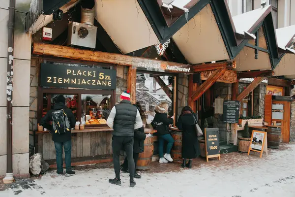 Comptoir de galettes de pommes de terre dans une rue enneigée de Zakopane
